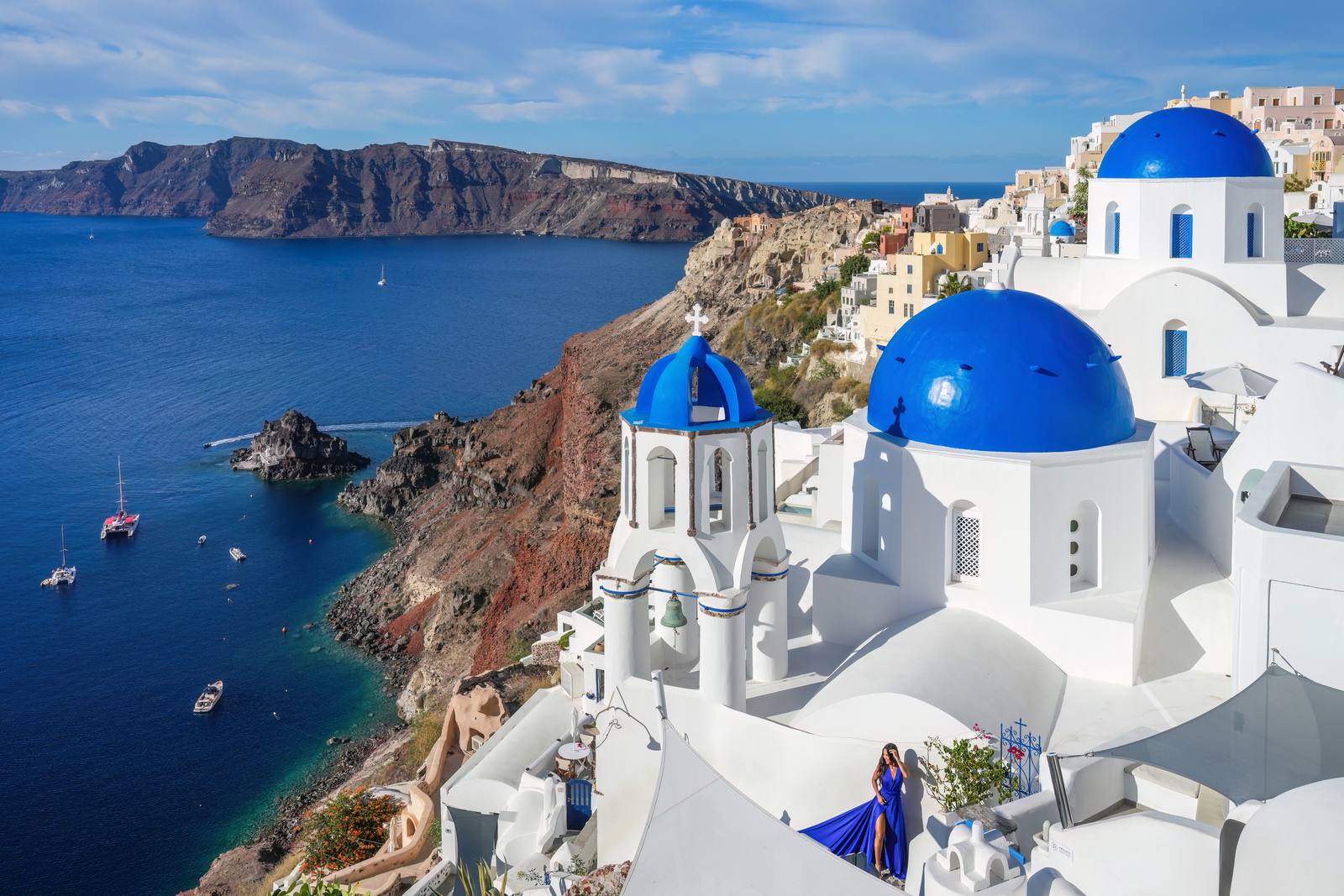 Cúpulas azuis de Oia, em Santorini, com a caldeira e o mar ao fundo