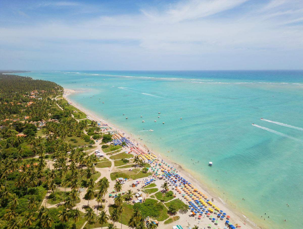 Vista aérea da praia de Antunes com coqueiral e mar azul-turquesa